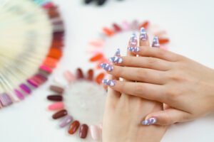 Well-groomed hands and nail color samples. Female hands with pastel manicure and nail color palette. Manicure nail polish color samples.