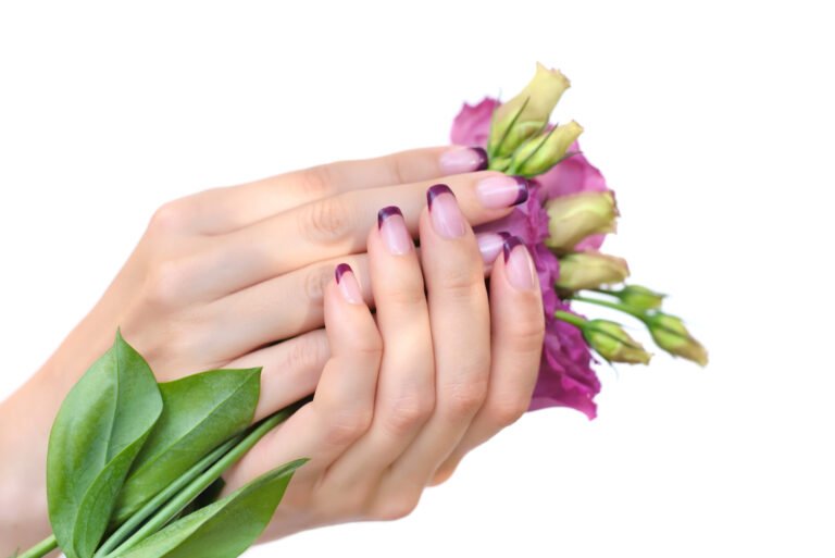 Hands of a woman with pink french manicure and flowers eustoma o